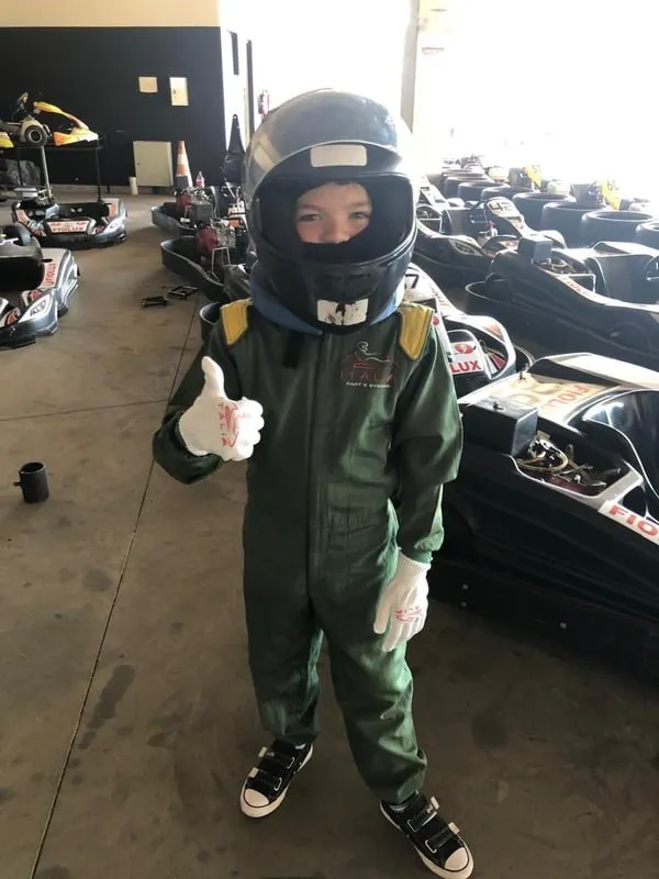 Lorenzo criança com capacete e macacão de piloto